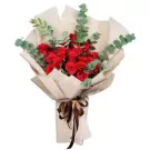 Bouquet of 48 red roses and eucalyptus, wrapped in cream paper and tied with a brown ribbon.