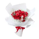 A bouquet of red roses and baby's breath, wrapped in white paper and tied with a red ribbon.
