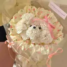 A white carnation bouquet shaped like a puppy in a floral wrapper.