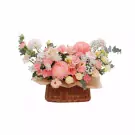 Pink and white flowers in a woven basket, including chrysanthemums, carnations, and lisianthus.
