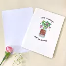 Card with plant illustration and "year of growth" text, next to white card and pink flower.