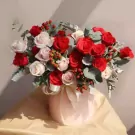Pink and red roses in a light pink box, tied with a ribbon.