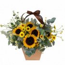 Basket arrangement of sunflowers, daisies, and eucalyptus with a brown ribbon.