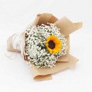 Bouquet of baby's breath with one sunflower, wrapped in brown paper.