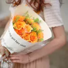 A bouquet of vibrant orange roses wrapped in paper with musical notes.