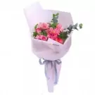 Pink and red floral bouquet wrapped in white paper with a gray ribbon.