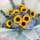 Bouquet of sunflowers and blue hydrangeas with eucalyptus leaves.