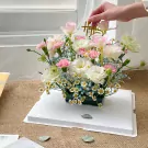 Floral arrangement with tulips, lisianthus, carnations, baby's breath, and tana daisies.