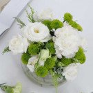 White roses and green button mums in a clear glass vase.