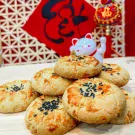 A stack of sesame seed cookies with a lucky cat figurine in the background.