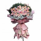 A lavish floral arrangement with pink gerbera daisies, purple statice, and baby's breath.