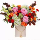 Box of pink peonies, orange roses, red carnations, hydrangeas, and succulents.