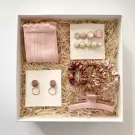 Pink gift box with socks, hair clips, earrings, scrunchies, and a claw clip.