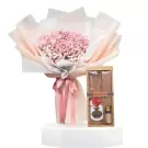 Pink baby's breath bouquet with a gift box containing a necklace, stone diffuser, and essential oil.