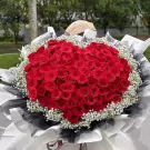 A heart-shaped bouquet of 101 red roses and baby's breath.