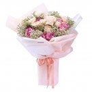 Bouquet of pink and white roses with baby's breath, wrapped in pale pink paper with a coral ribbon.