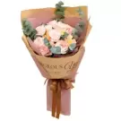 A bouquet of pink and white roses with eucalyptus leaves, wrapped in brown and pink paper.