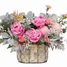 Pink peonies and other flowers in a wire basket with lace ribbon.