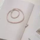 Pearl necklace and earrings on an open book.