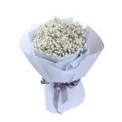 A light blue bouquet of baby's breath flowers wrapped in light blue paper and tied with a grey ribbon.