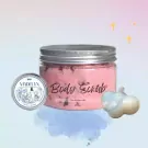 A jar of pink body scrub next to a small tin and a cloud-shaped charm.