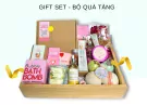 Gift set with bath bombs, body oil, body scrub, incense, and perfume in a wooden tray.