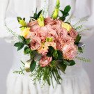 A rustic bouquet of pink roses, yellow lisianthus, and greenery with a hint of gold.