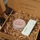 Candle in a box with shredded paper, a floral design lid, and a "GOOD DAY" tag.