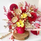 Red and gold flower box with traditional decorations for Lunar New Year celebration.