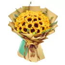 Bouquet of 36 bright sunflowers with eucalyptus leaves in brown and teal wrapping.