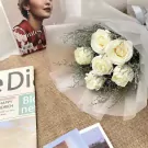 White roses bouquet, "hautes" magazine, "eDia" book, and photos on burlap.