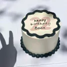 White cake with black frosting border, "happy birthday Baba" and "22" in pink.