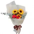 Bouquet of sunflowers and red roses with eucalyptus leaves, wrapped in pale paper with a brown ribbon.