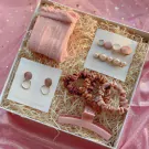 Pink gift box with socks, earrings, hair clips, scrunchies, and hair claw.