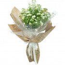 Bouquet of white aster flowers wrapped in brown paper with white ribbon.