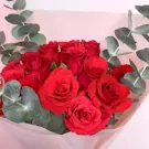 A bouquet of red roses and eucalyptus.