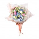 A bouquet of pink roses, blue hydrangeas, white daisies, and baby's breath wrapped in pink paper.
