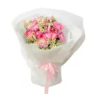 Pink carnation bouquet with white daisies and pink bunny tail grass, wrapped in white paper with a pink bow.