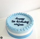 Blue ombre cake with "happy 1st birthday wujae" written in navy blue frosting.