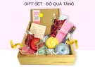 Gift box with bath bomb, soap, body oil, rose petals, and note.