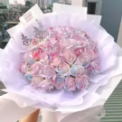 Multicolor roses and a silver crown in a white bouquet.