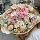 A romantic bouquet of pink and cream roses, carnations, and daisies.