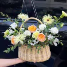 Basket of peach, cream, and white flowers.
