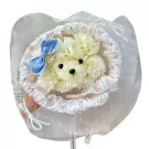 White floral puppy bouquet with blue gingham bow, wrapped in sheer fabric.