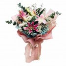 Pink lilies, white daisies, and baby's breath in a bouquet with pink wrapping.