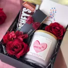 Valentine's gift box with Hershey's bar, candle, red roses, and card.