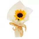 A single sunflower in a bouquet with sheer cream paper wrapping and a golden ribbon.