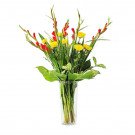Red gladiolus and yellow mums in a clear vase.