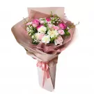 Pink and white floral bouquet with roses, carnations, and baby's breath, wrapped in soft pink paper.