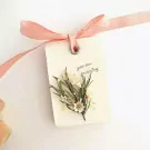 Scented candle gift box with dried flowers and ribbon.